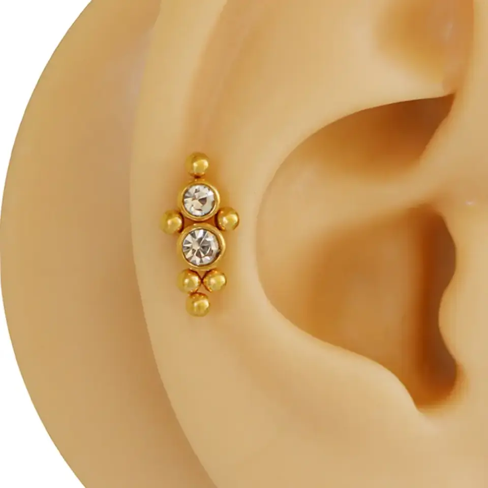 Altın renk toplu zirkon taşlı kıkırdak piercingi flatback modelinin makro çekimi