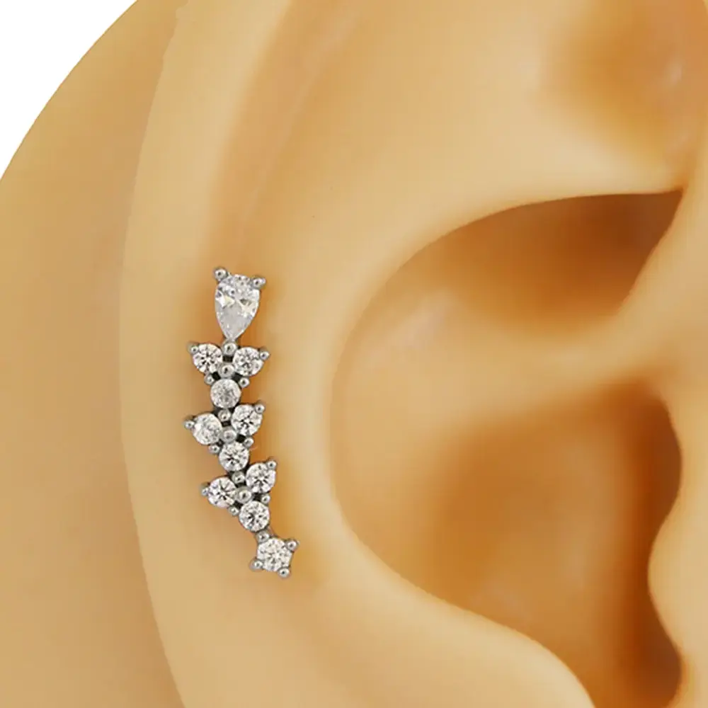 Sıra zirkon taşlı gümüş renk 316L cerrahi çelik tragus piercing flatback detay çekimi.