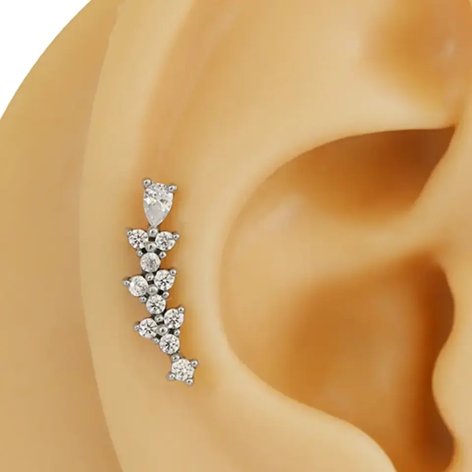 Sıra zirkon taşlı gümüş renk 316L cerrahi çelik tragus piercing flatback detay çekimi.