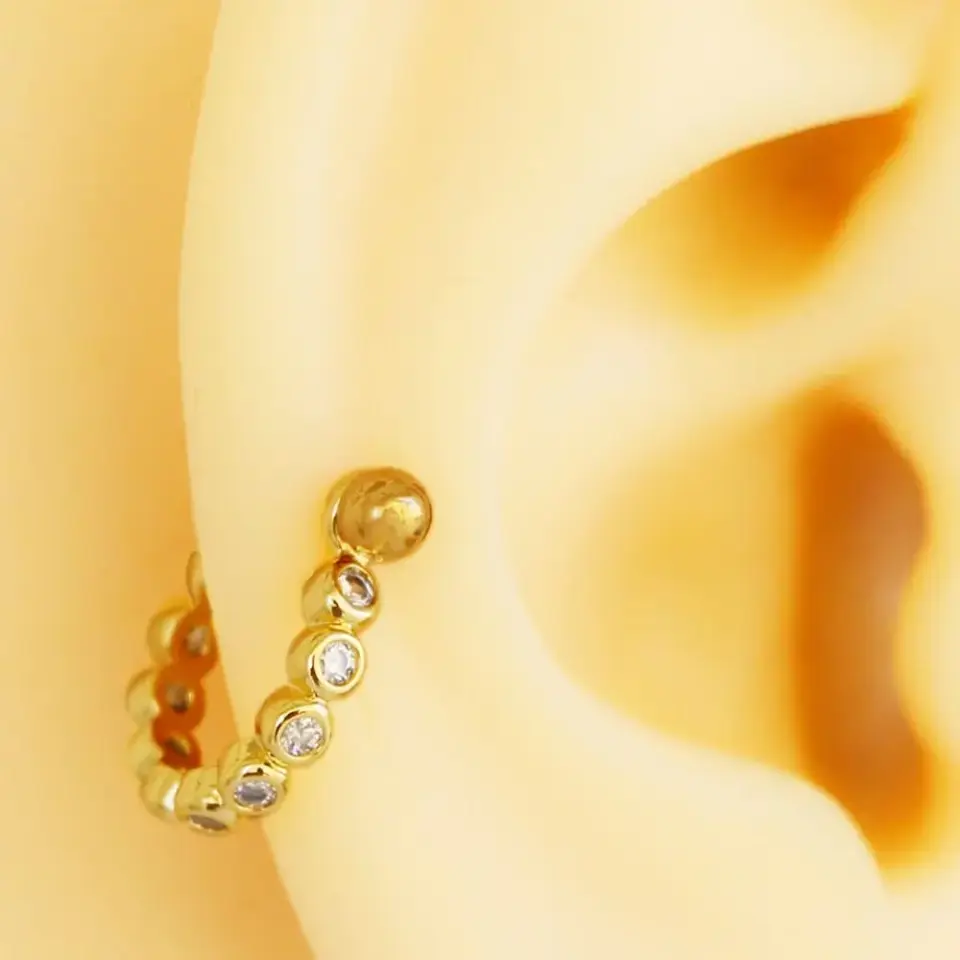 Altın rengi yuvarlak zirkon taşlı helix, kıkırdak piercing kulakta duruş