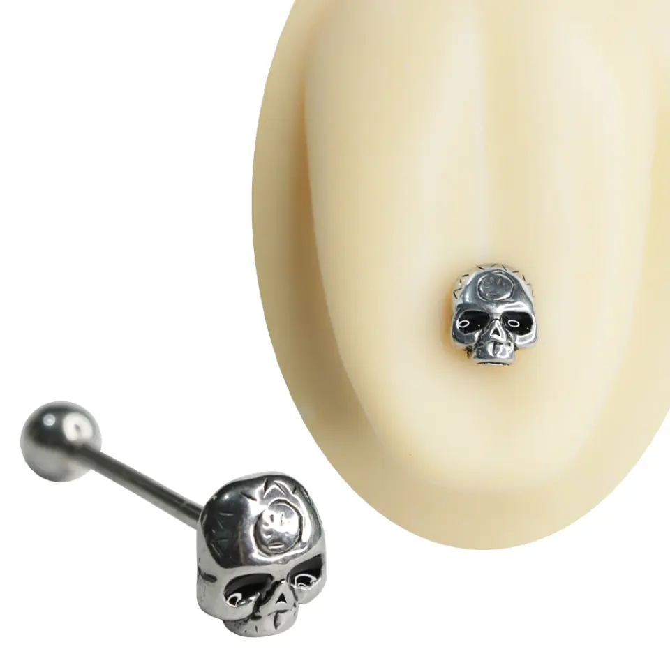 Gümüş renkli 316L cerrahi çelikten üretilmiş, detaylı kurukafa figürlü gotik dil piercing ve 19 mm uzunluğundaki dil barı görünümü.