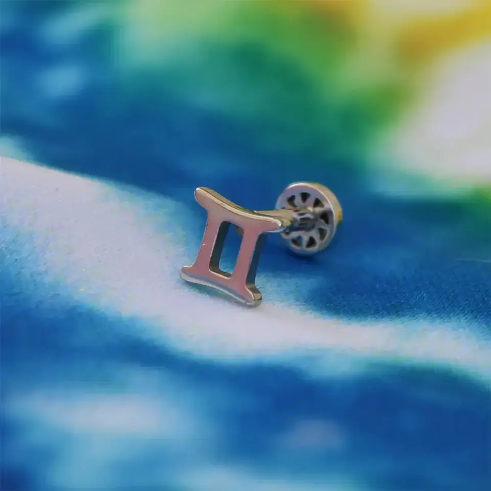 Tragus piercing flatback (arkası düz) vidalı sistem yakından çekimi.