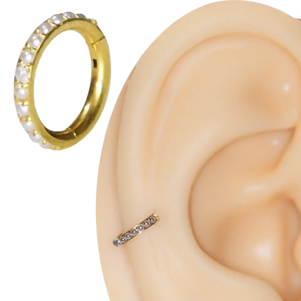 inci taşlı altın renkli halka burun tragus piercingin kulakta görünümü