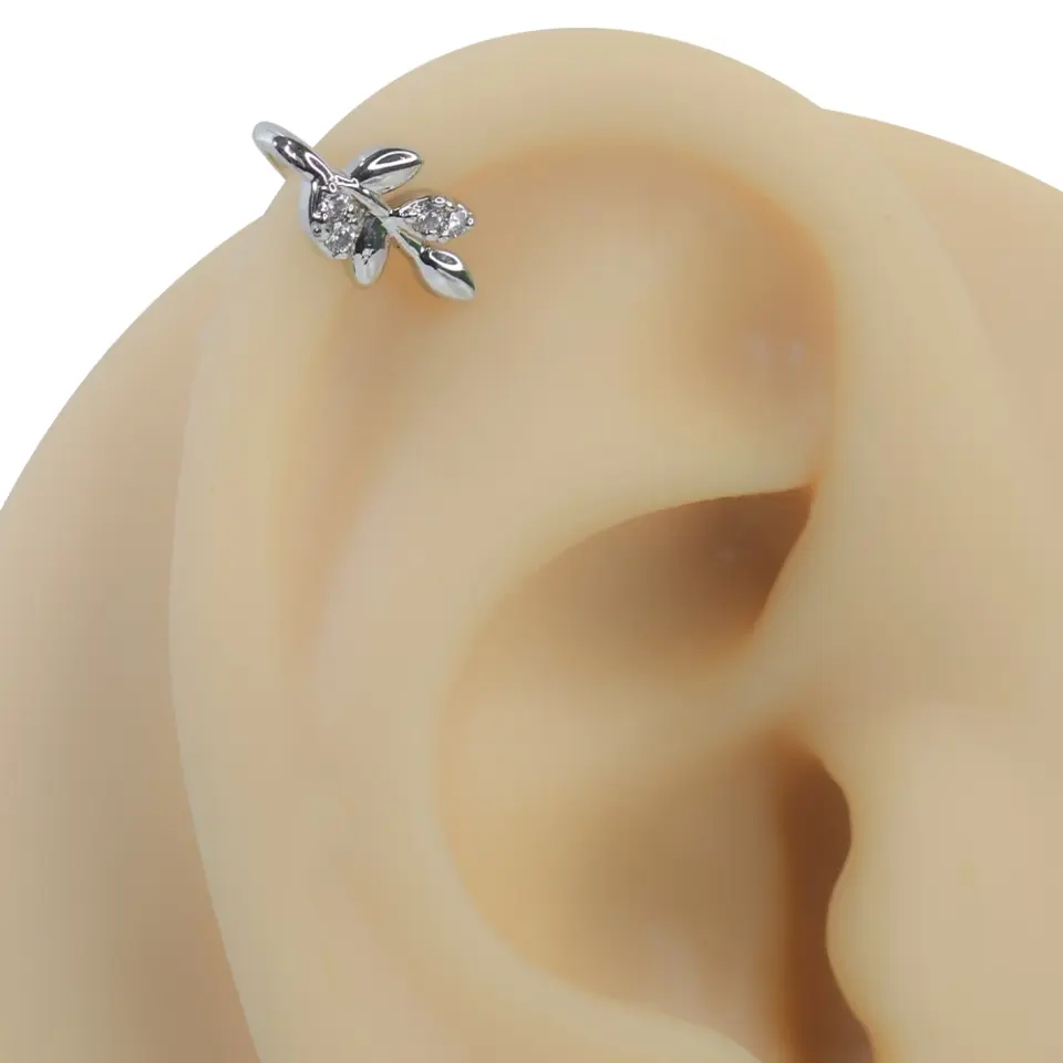 Gümüş rengi yaşam filizi zirkon taşlı sıkıştırma kıkırdak piercing modelinin kulak üzerindeki estetik duruşu