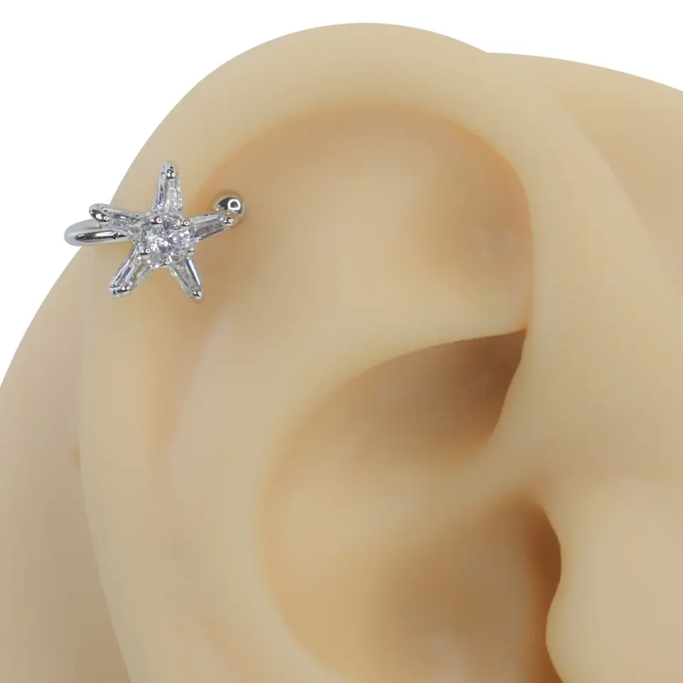 Gümüş rengi deniz yıldızı zirkon taşlı sıkıştırma kıkırdak piercing modelinin kulak üzerindeki marin temalı duruşu