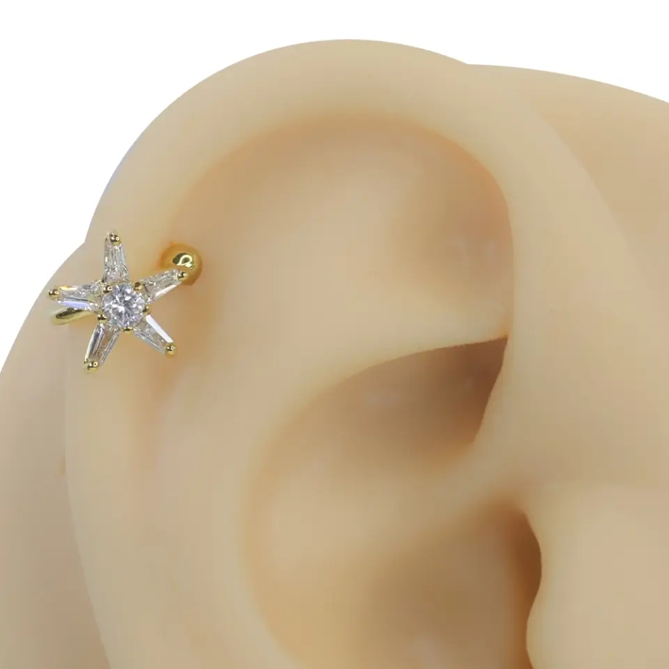 Altın rengi deniz yıldızı zirkon taşlı sıkıştırma kıkırdak piercing modelinin kulak üzerindeki lüks ve parıltılı duruşu
