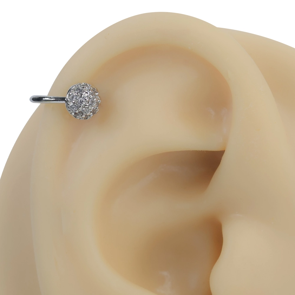 Gümüş rengi ışık küresi zirkon taşlı sıkıştırma kıkırdak piercing modelinin kulak üzerindeki modern ve minimal duruşu