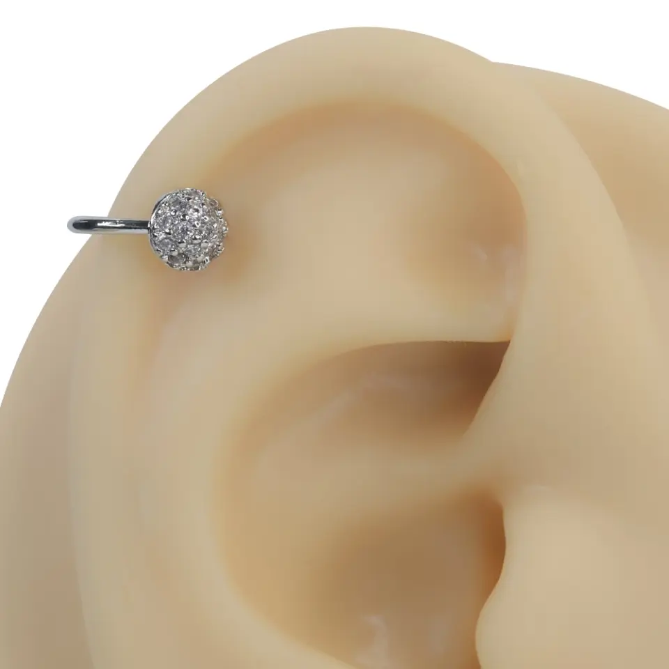 Gümüş rengi ışık küresi zirkon taşlı sıkıştırma kıkırdak piercing modelinin kulak üzerindeki modern ve minimal duruşu