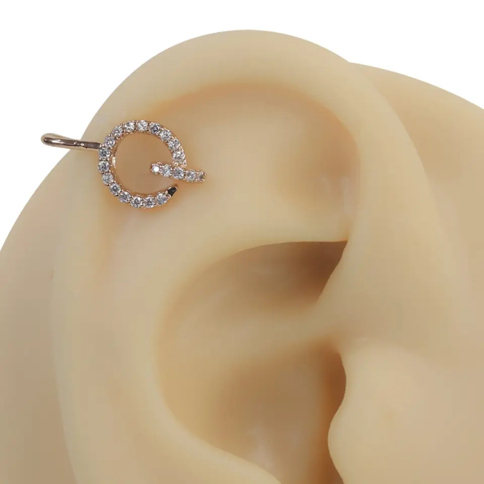 Rose gold gizemli mühür zirkon taşlı sıkıştırma kıkırdak piercing modelinin kulak üzerindeki parıltılı ve mistik duruşu