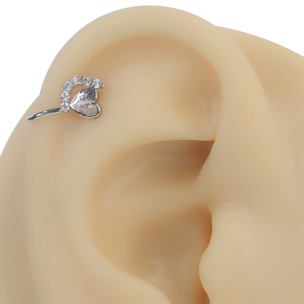Gümüş rengi ışığın kalbi zirkon taşlı sıkıştırma kıkırdak piercing modelinin kulak üzerindeki modern ve asil duruşu