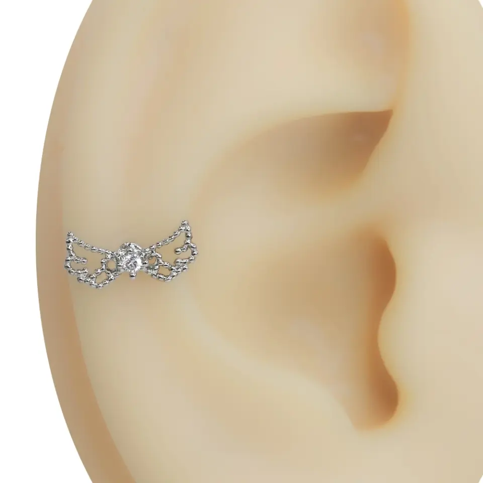 Kulak üzerinde sergilenen zirkon taşlı gümüş renkli tragus helix kıkırdak piercing modeli