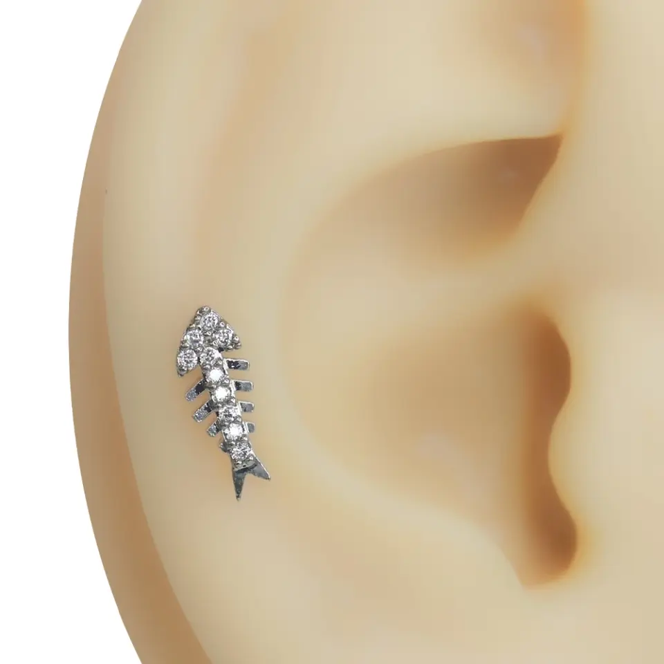 Kıkırdak bölgesinde sergilenen kılçık formlu zirkon taşlı gümüş renkli piercing