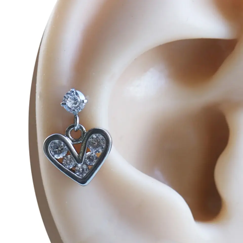 Kulak kıkırdak bölgesinde sergilenen sallantılı kalp figürlü gümüş Romantizm piercing