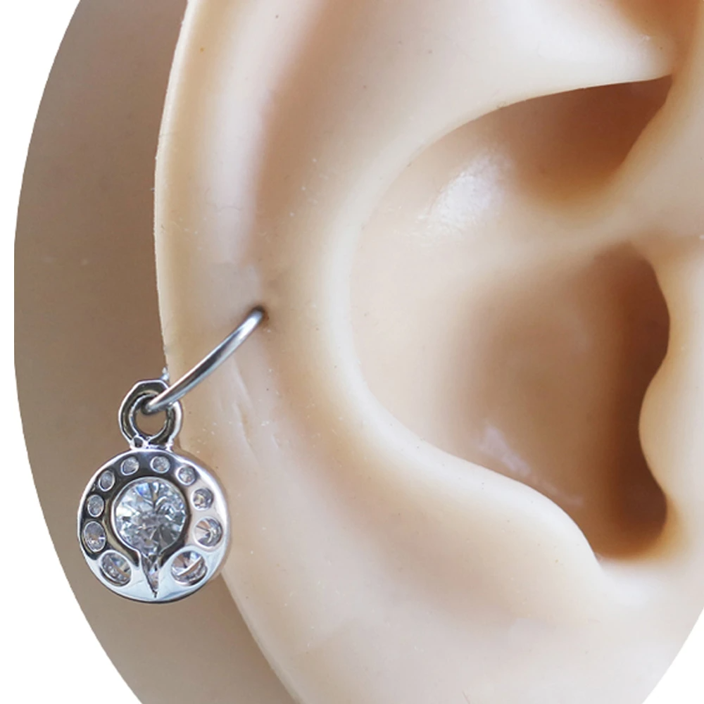 Kulak kıkırdak bölgesinde sergilenen zirkon taşlı gümüş Işık Gözü piercing modeli