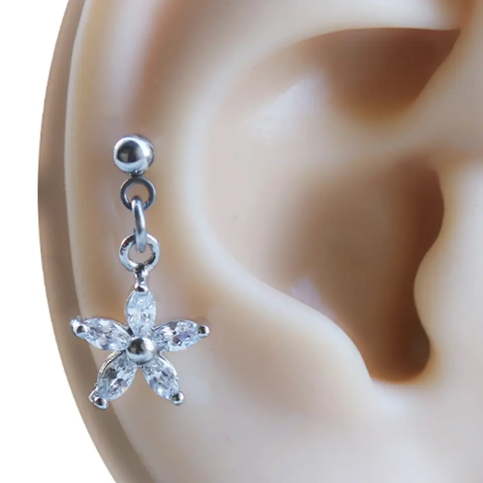 Kulak üzerinde sergilenen zirkon taşlı gümüş çiçek figürlü tragus helix kıkırdak piercing