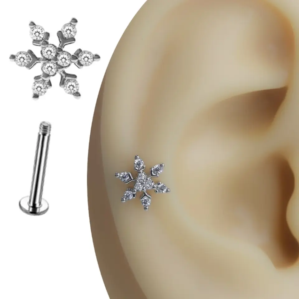 Kulak üzerinde kar tanesi figürlü gümüş rengi tragus helix kıkırdak piercing duruşu