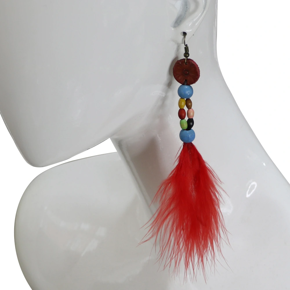 Kulak üzerinde sergilenen kırmızı tüy ve mavi boncuk detaylı el yapımı deri küpe