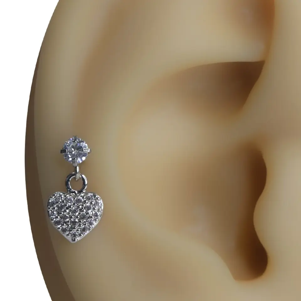 Kulak kıkırdağında sergilenen zirkon taşlı kalp figürlü gümüş renk tragus helix kıkırdak piercing