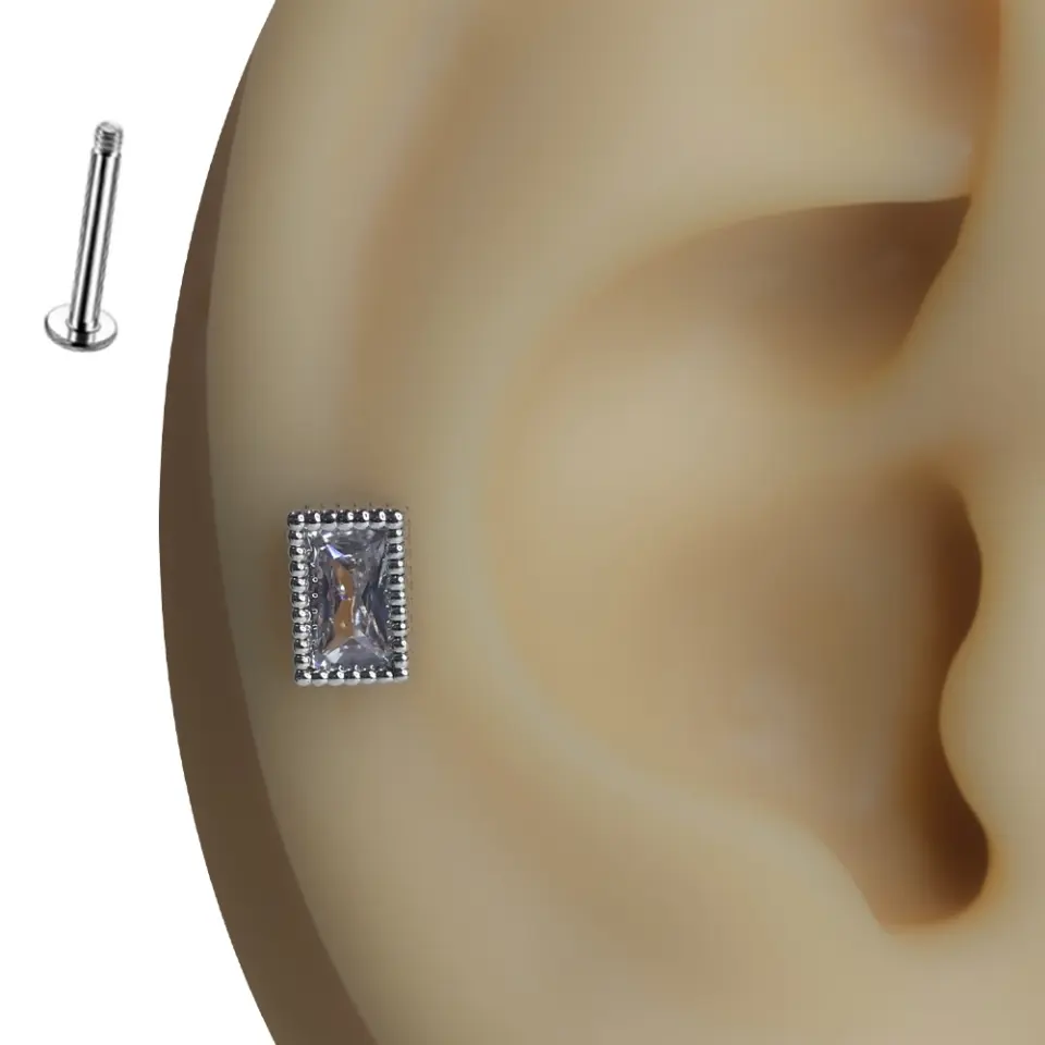 Kulak üzerinde sergilenen zirkon taşlı oval formlu gümüş renk tragus helix kıkırdak piercing