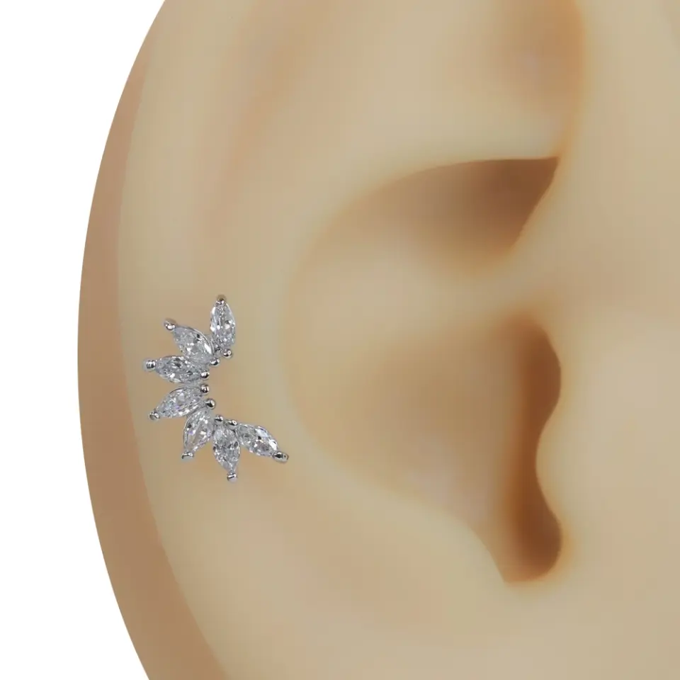 Kulak üzerinde sergilenen gümüş renk yelpaze model tragus helix kıkırdak piercing.