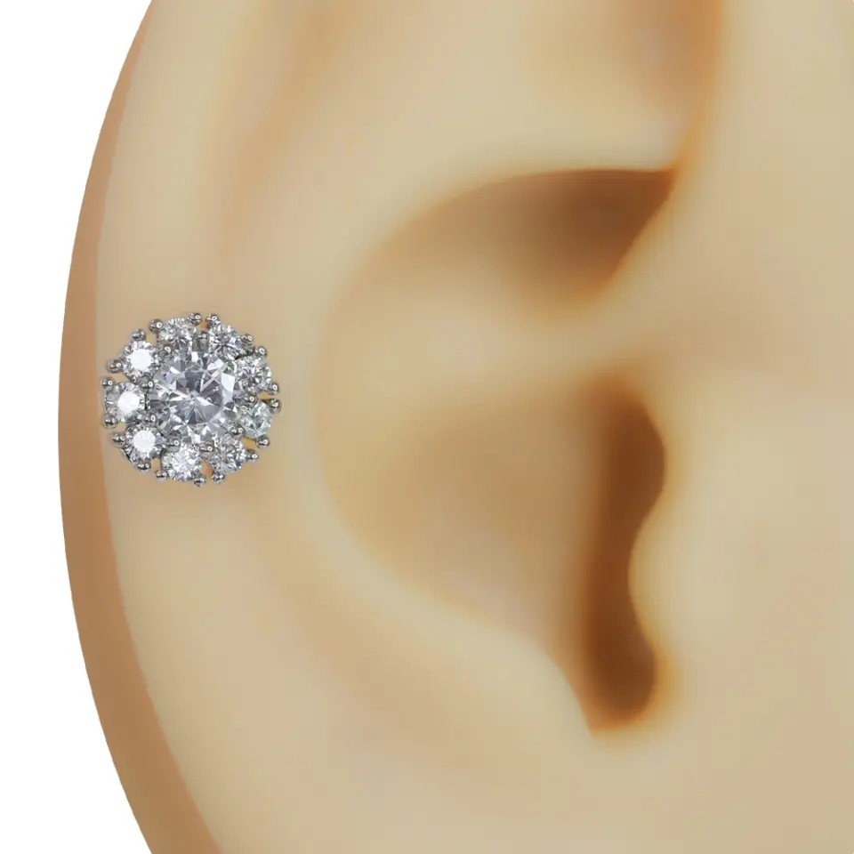 Kulağa takılmış zirkon taşlı çiçek gümüş rengi tragus helix kıkırdak piercing modeli