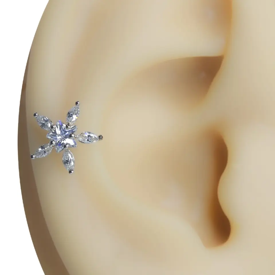 Gümüş Kar kar tanesi formlu tragus helix kıkırdak piercing modelinin kulak kıkırdağındaki zarif görünümü