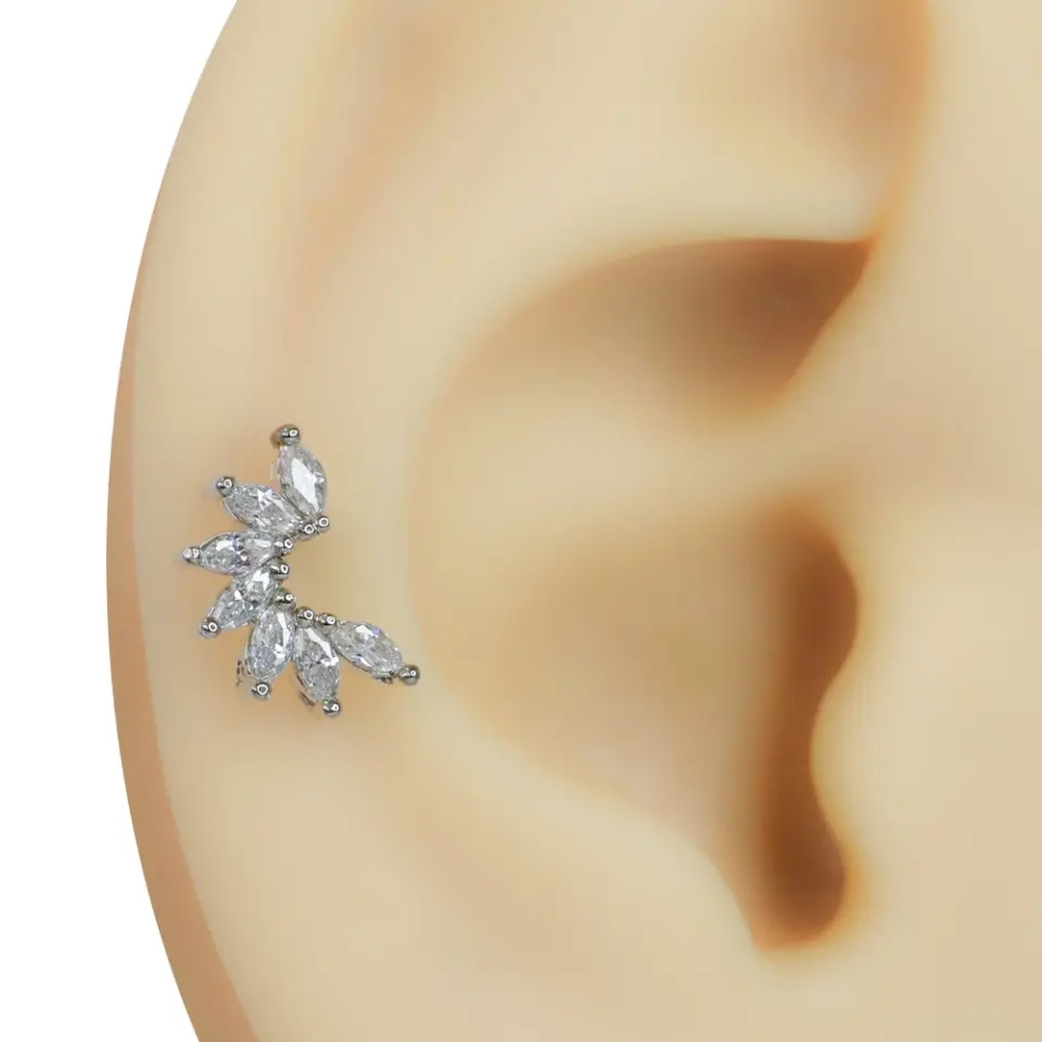 Kulağa takılmış zirkon taşlı kavis gümüş rengi tragus helix kıkırdak piercing modeli