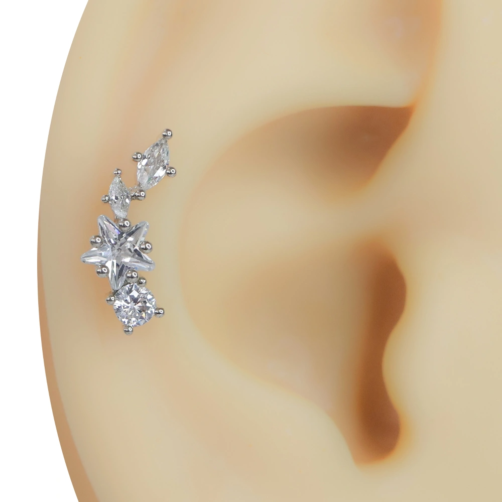 Kulağa takılmış zirkon taşlı yıldız gümüş rengi tragus helix kıkırdak piercing modeli
