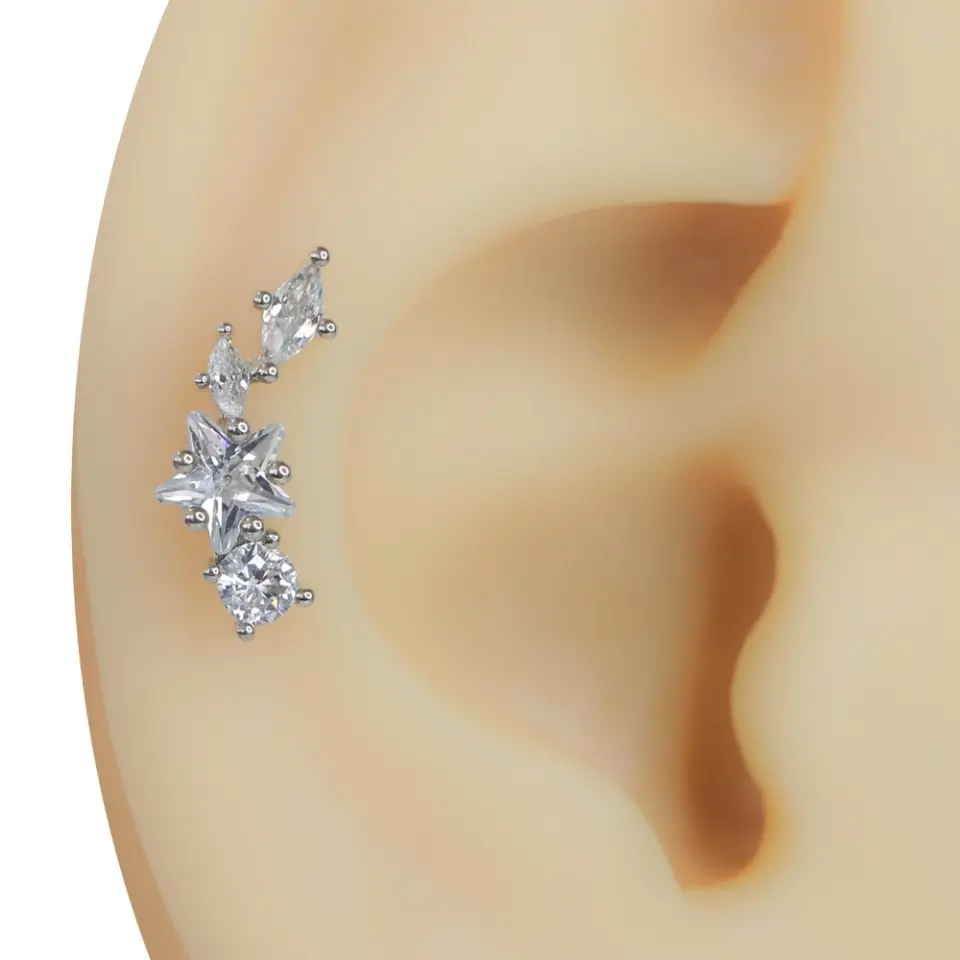 Kulağa takılmış zirkon taşlı yıldız gümüş rengi tragus helix kıkırdak piercing modeli