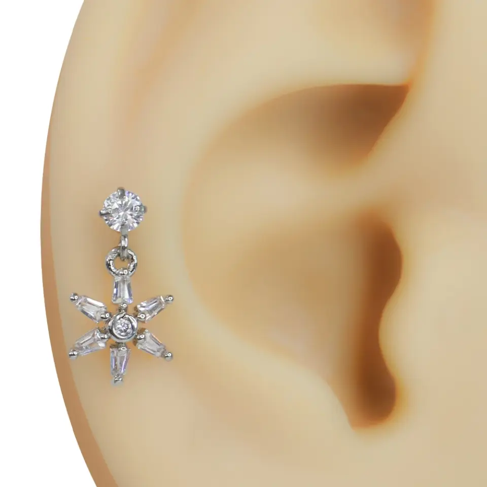 Kulağa takılmış sarkıt detaylı zirkon taşlı yıldız çiçek gümüş rengi tragus helix kıkırdak piercing modeli
