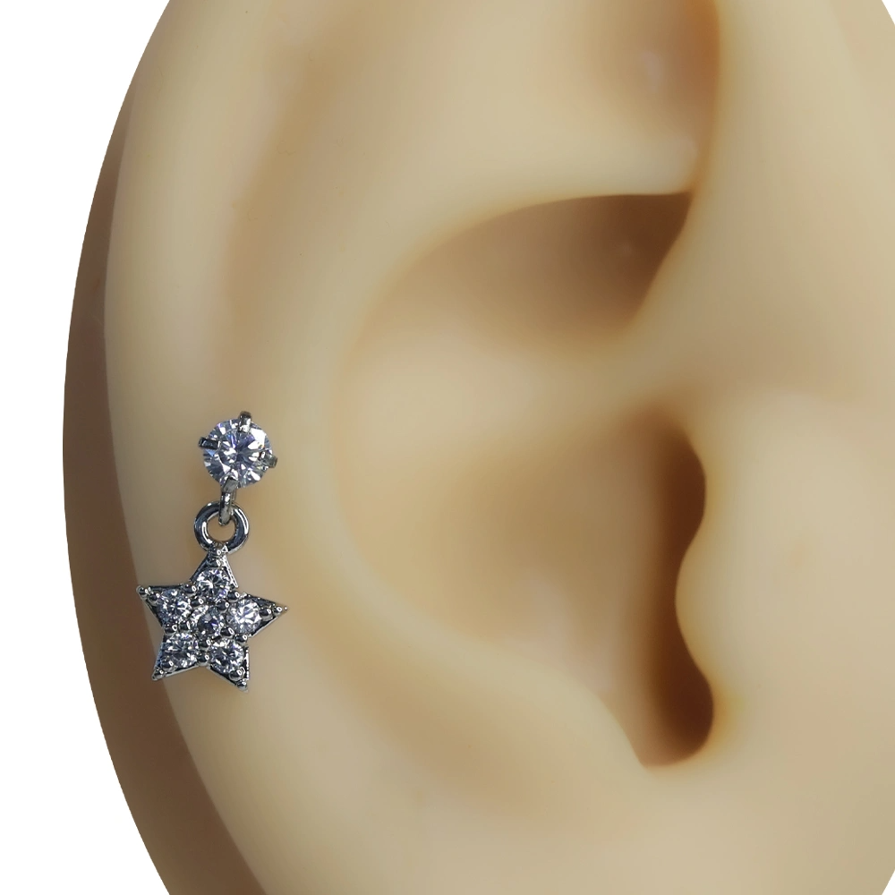 Kulakta sallantılı yıldız figürlü tragus helix kıkırdak piercing sergilenmesi.