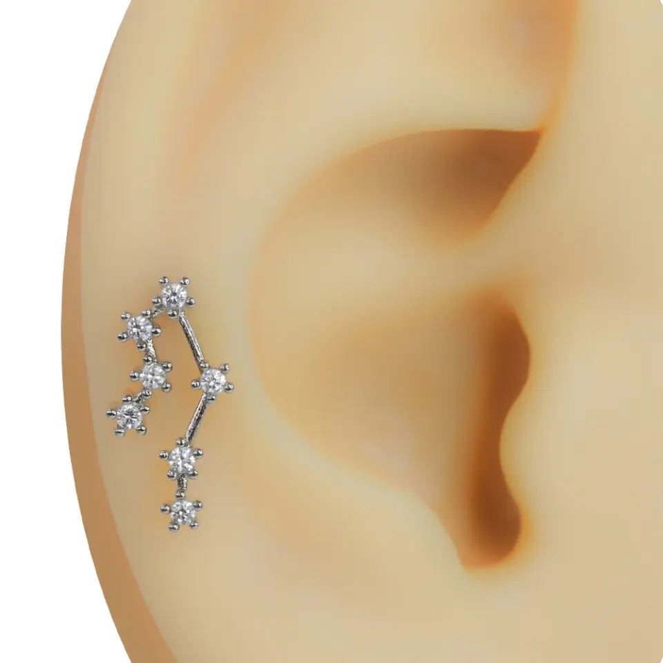 Kulakta takılı duran gümüş renkli yıldız kümesi model zirkon taşlı tragus helix kıkırdak piercing küpesi
