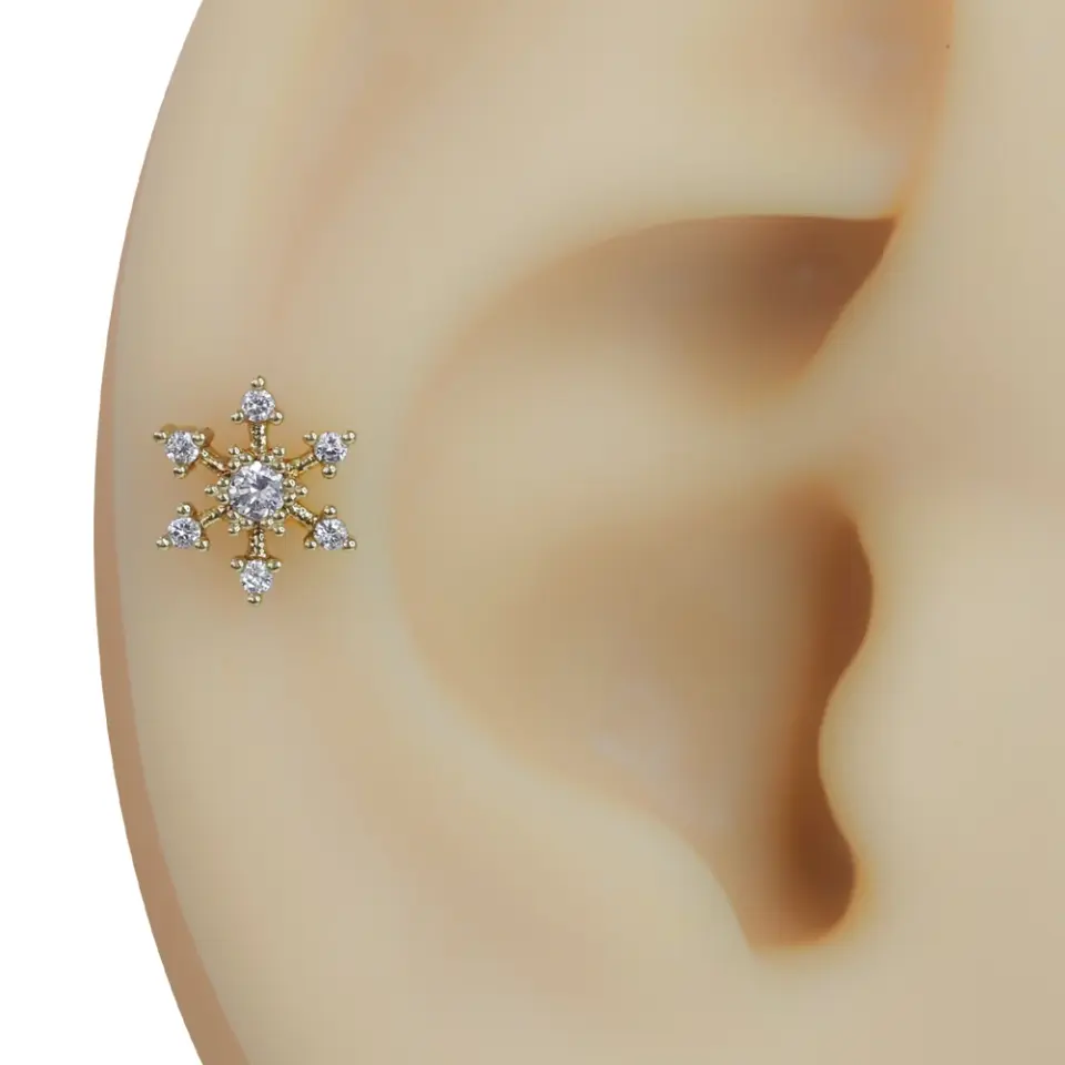 Kulak kıkırdağında takılı gold renkli kar tanesi model zirkon taşlı tragus helix kıkırdak piercing
