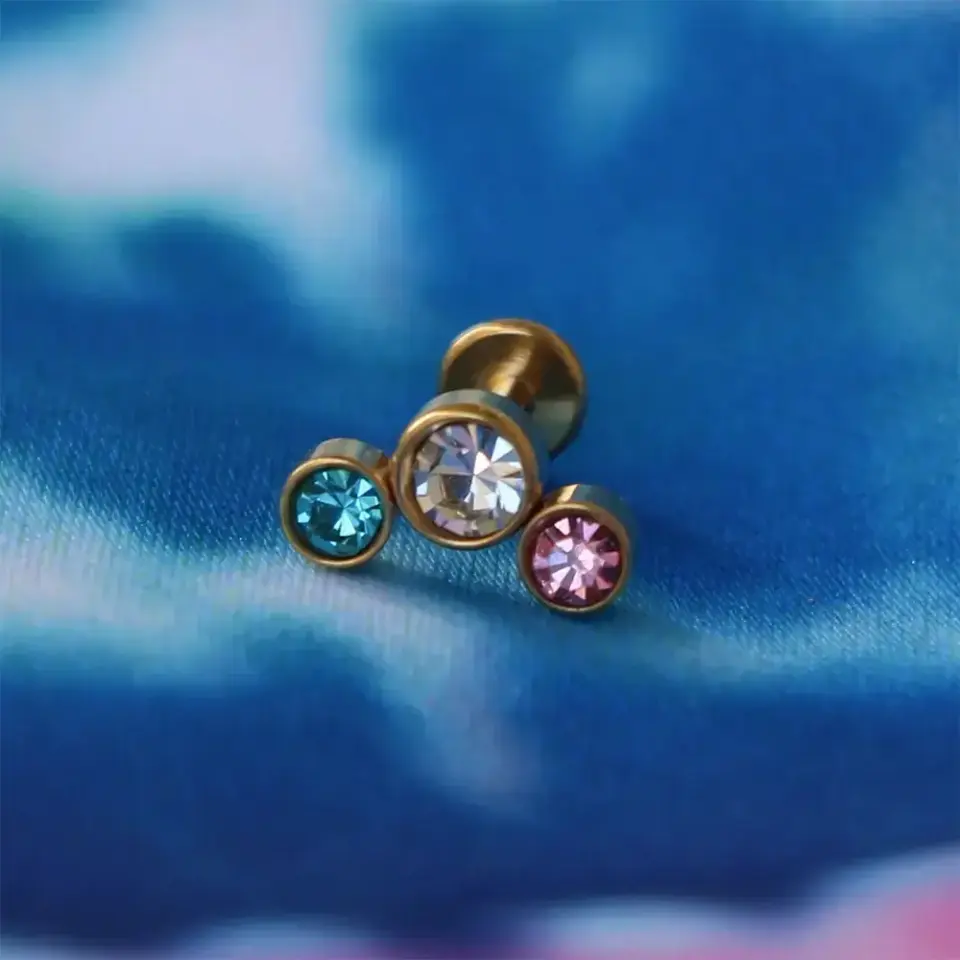 Flatback arkası düz vidalı gold renkli taşlı piercing teknik görünüm.