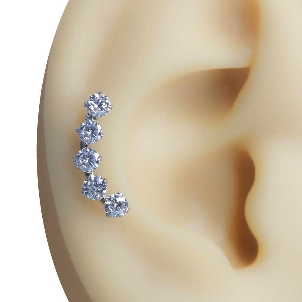 Kulak kıkırdak ve helix bölgesini saran beş taşlı Ruhun Akışı piercing kombinasyonu.