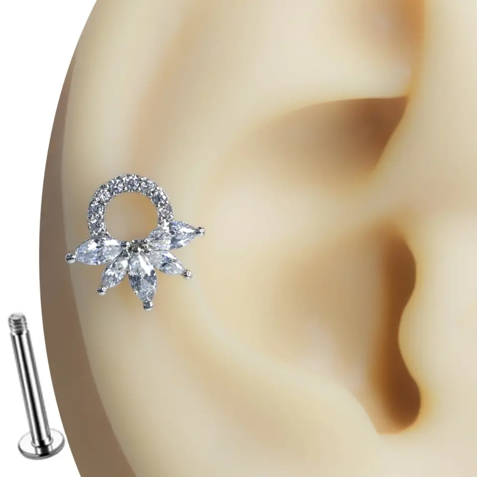 Kulakta sergilenen taç formunda markiz taşlı tragus helix kıkırdak piercing tasarımı.