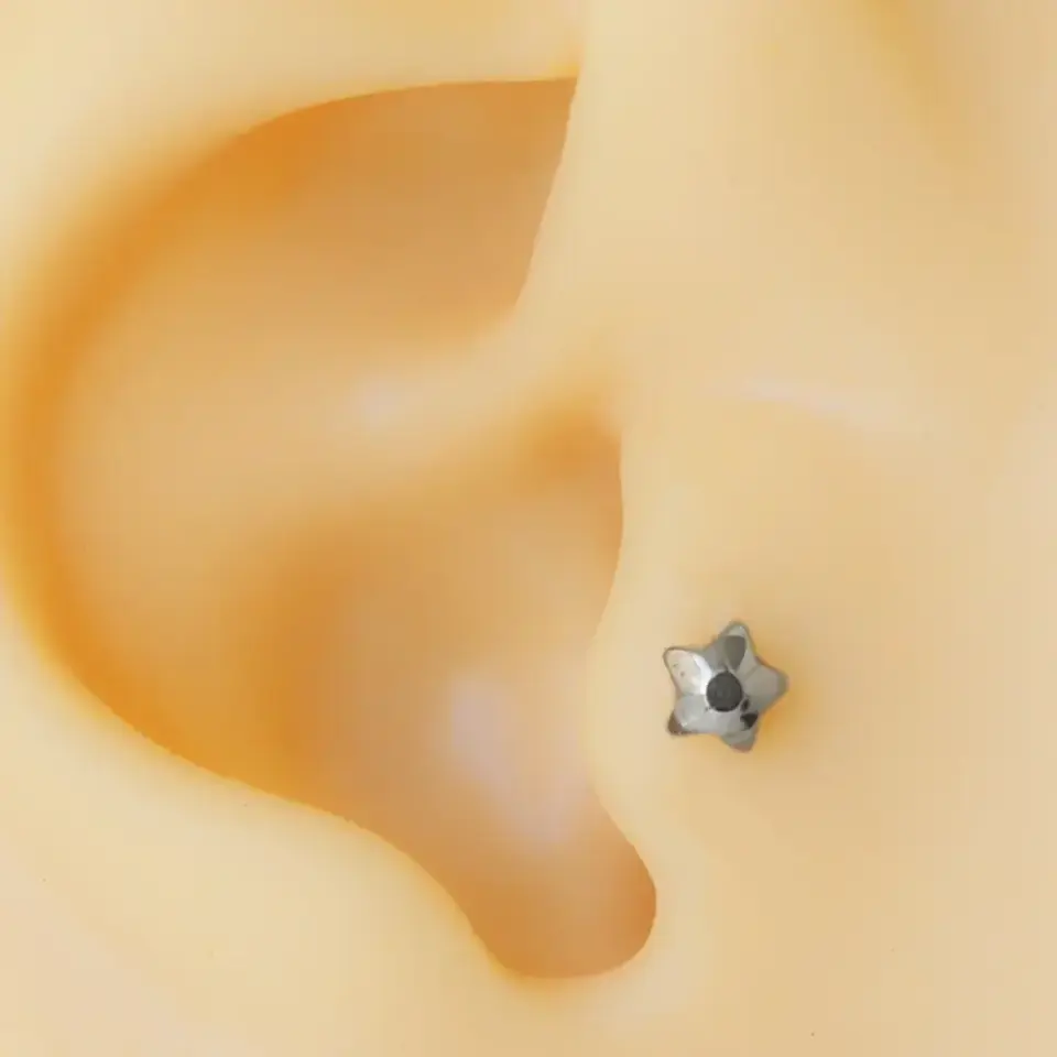 Gümüş renk minimal yıldız modelli cerrahi çelik tragus piercing.
