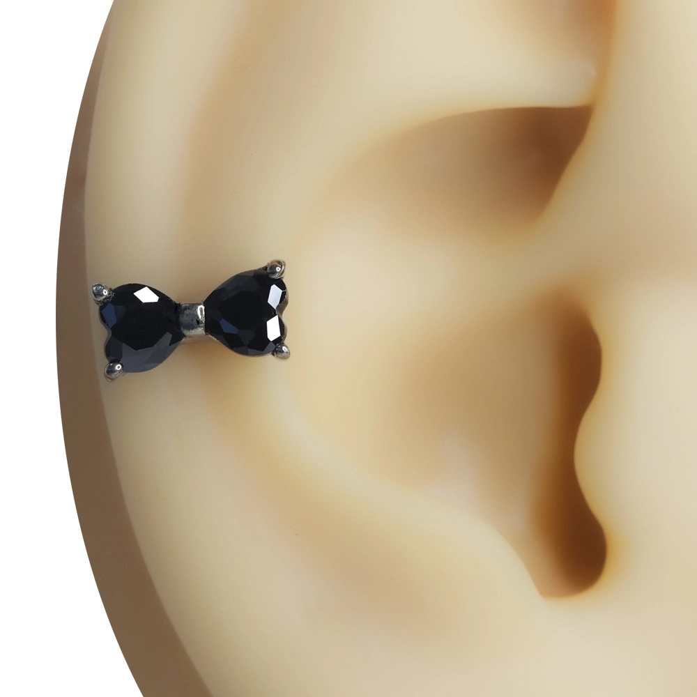 Kulak üzerinde sergilenen siyah zirkon taşlı fiyonk figürlü tragus helix kıkırdak piercing