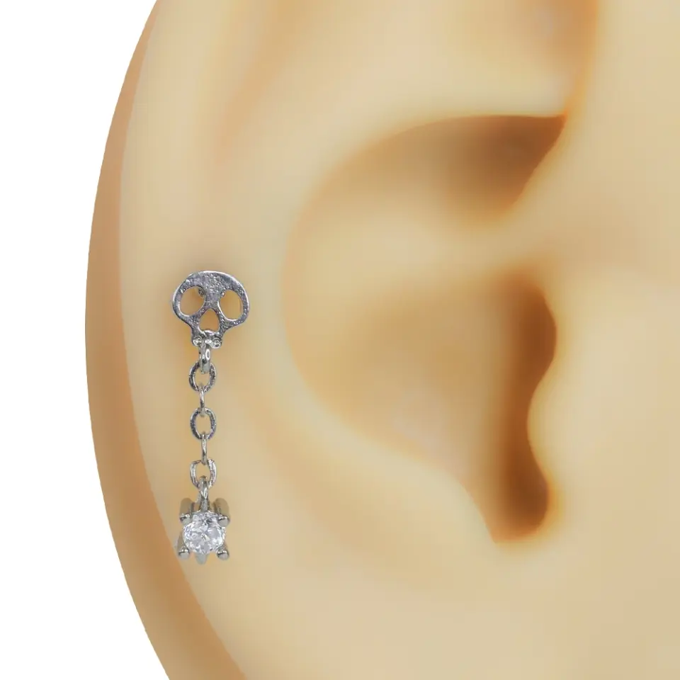 Kulak kıkırdağında sergilenen zirkon taşlı sallantılı kurukafa model gümüş rengi tragus helix kıkırdak piercing