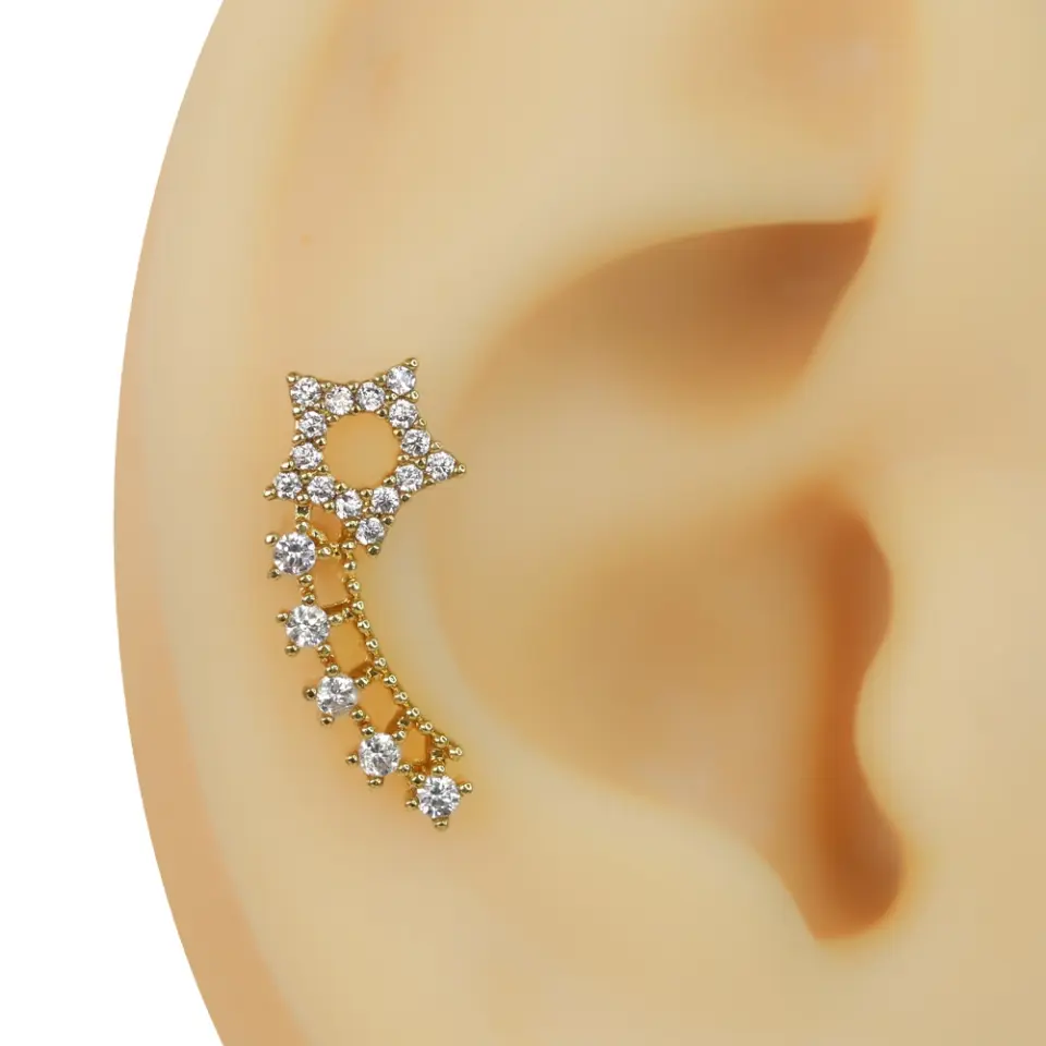Kulak üzerinde parlayan zirkon taşlı altın kuyruklu yıldız tragus helix kıkırdak piercing