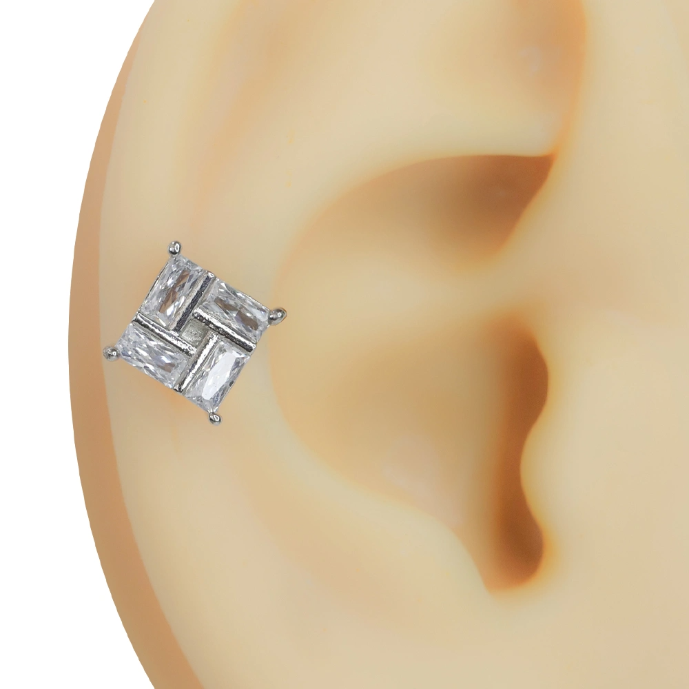 Kulakta duruşu ve net tasarımı sergilenen zirkon taşlı kare model gümüş rengi tragus helix kıkırdak piercing