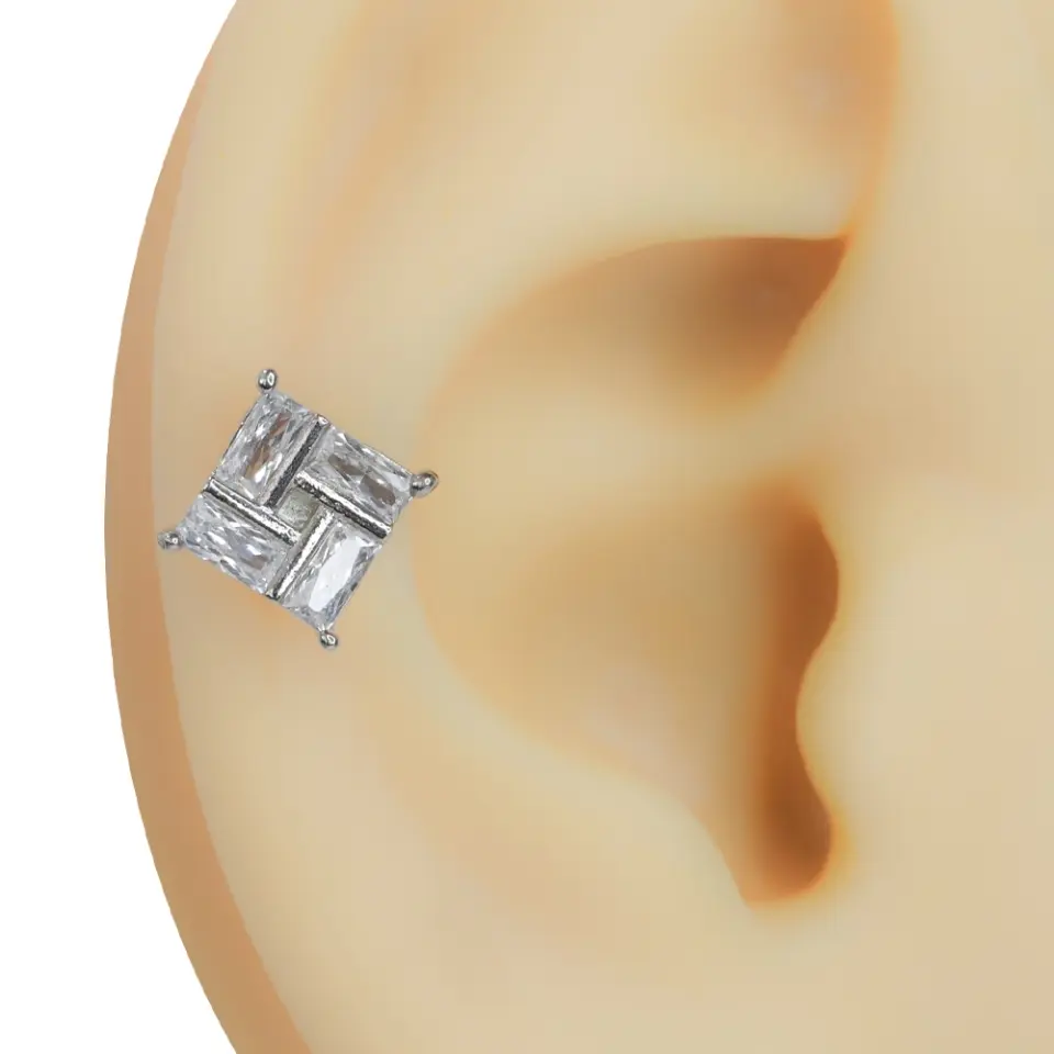 Kulakta duruşu ve net tasarımı sergilenen zirkon taşlı kare model gümüş rengi tragus helix kıkırdak piercing