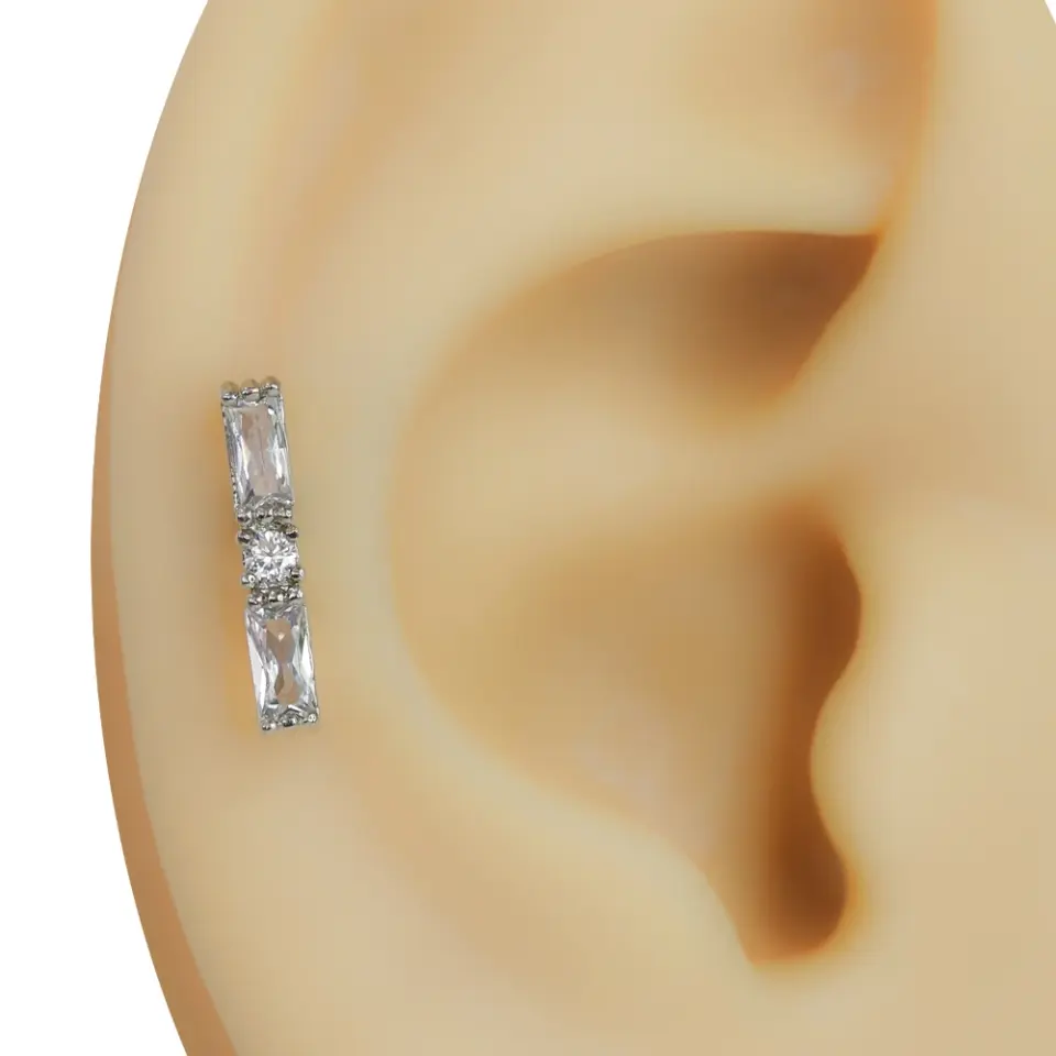 Kulakta duruşu ve dikey tasarımı sergilenen zirkon taşlı çubuk model gümüş rengi tragus helix kıkırdak piercing