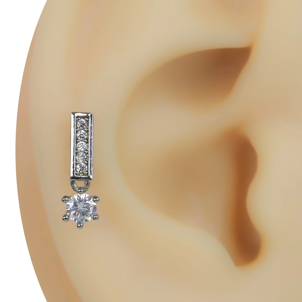 Kulak tragus bölgesinde sergilenen baget taşlı gümüş renk ışık koridoru piercing