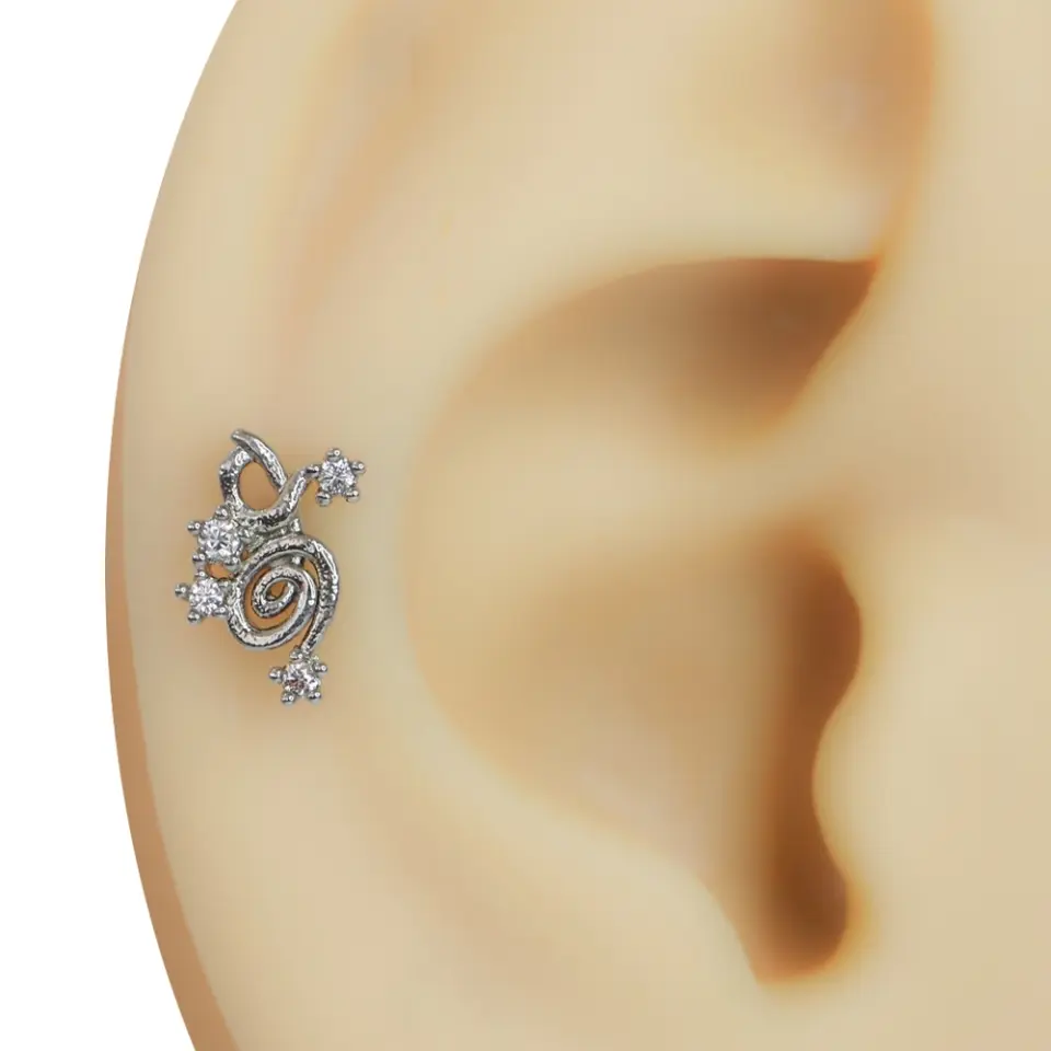 Kulakta duruşu ve sarmal tasarımı sergilenen zirkon taşlı spiralli model gümüş rengi tragus helix kıkırdak piercing