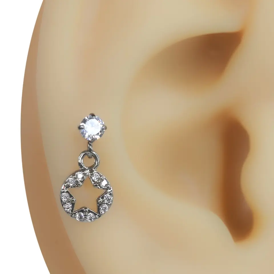 Kulak kıkırdak bölgesinde sergilenen zirkon taşlı yıldız pencere figürlü gümüş renk piercing