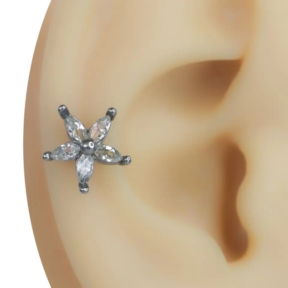 Kulak üzerinde sergilenen zirkon taşlı çiçek figürlü gümüş renk tragus helix kıkırdak piercing