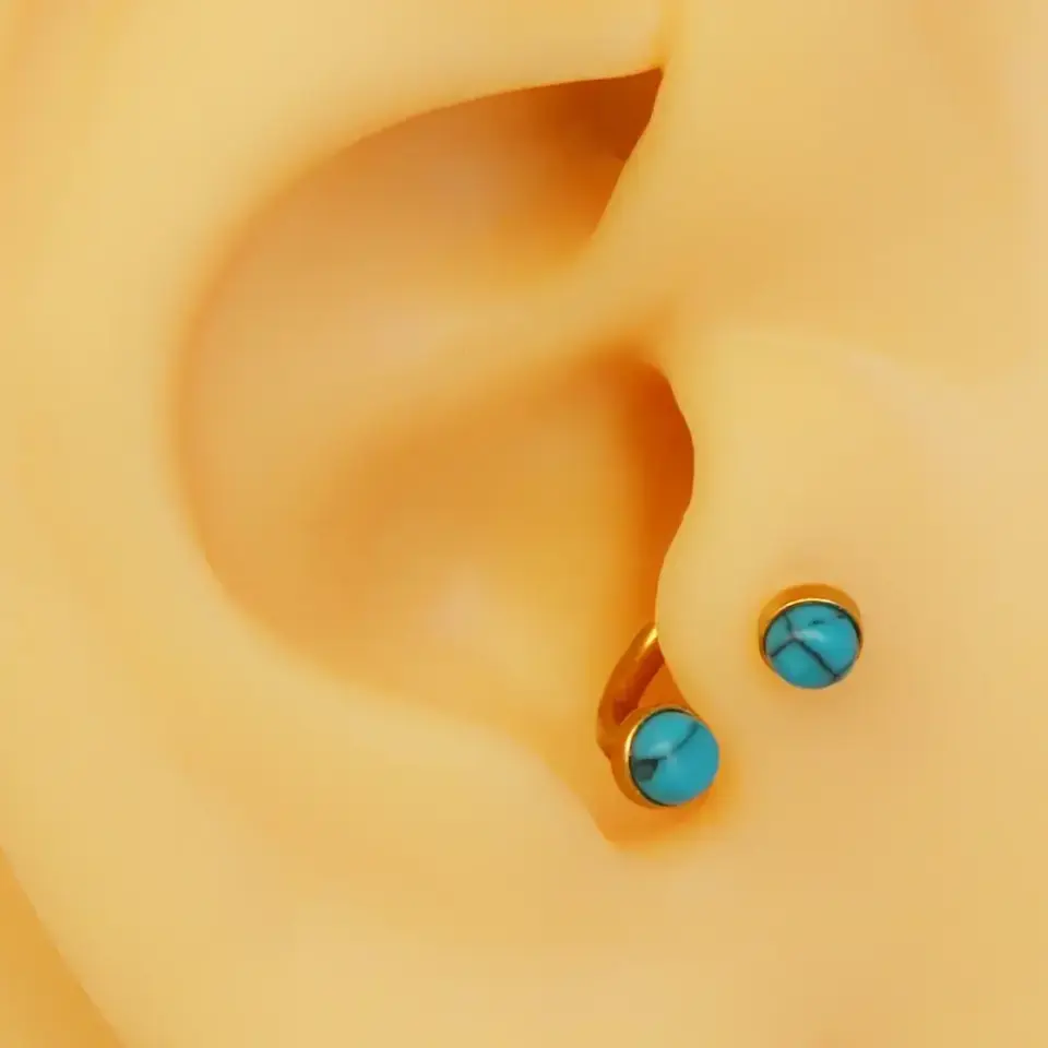 Altın renk turkuaz taşlı 316L cerrahi çelik yarım halka tragus piercing modeli.