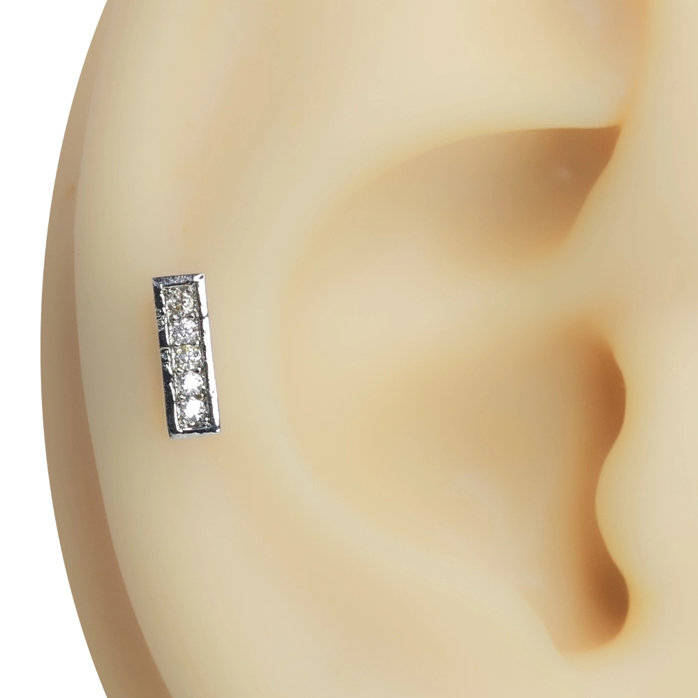 Kulak kıkırdak bölgesinde dikey duruş sergileyen zirkon taşlı Işık Çizgisi piercing