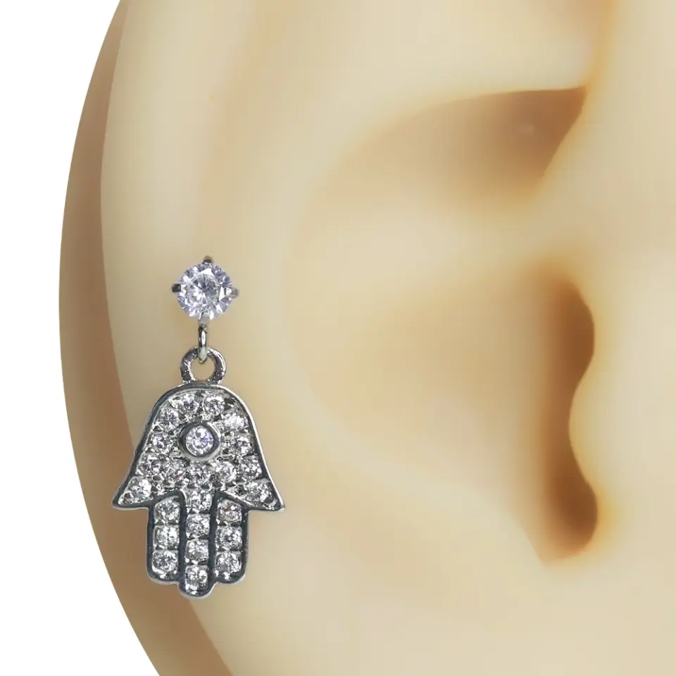 Kulak üzerinde sergilenen zirkon taşlı Fatma Ana Eli tragus helix kıkırdak piercing